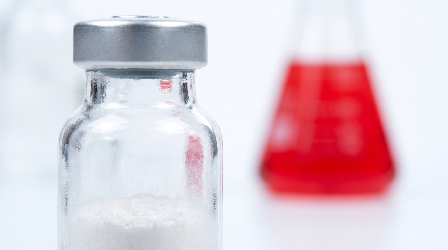 Macro de vial de investigación sin etiqueta con compuesto liofilizado en laboratorio blanco
