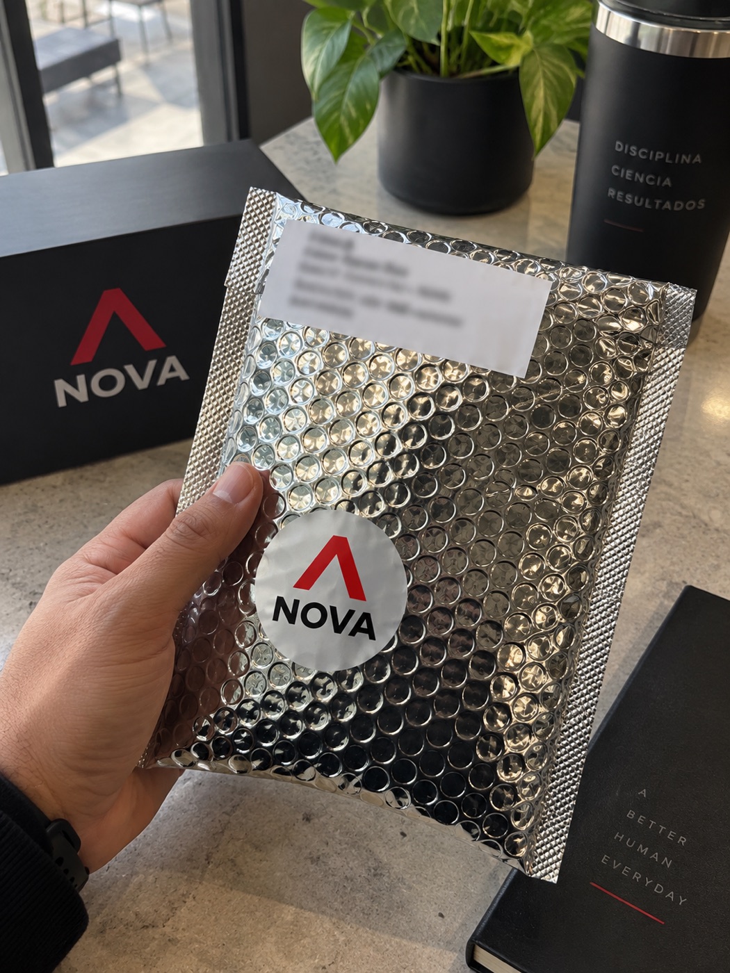 Paquete Nova con su caja negra, recibido por un cliente